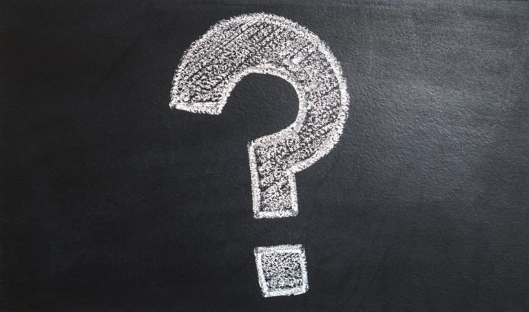 A large question mark drawn in white chalk on a blackboard.
